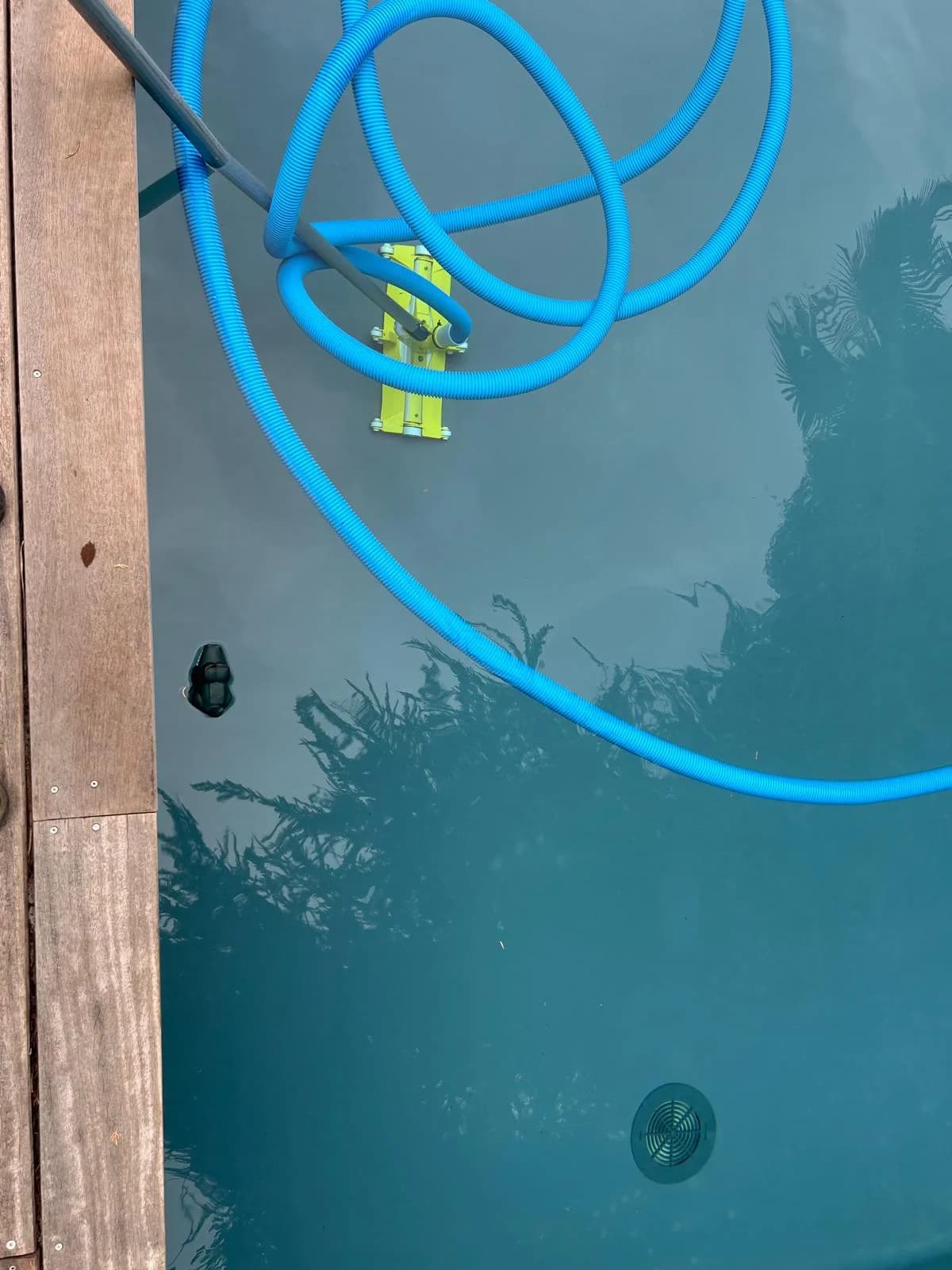 Surface d'eau troublée avec robot de nettoyage — piscine en cours de traitement